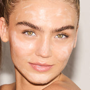 Model with cleanser all over her face