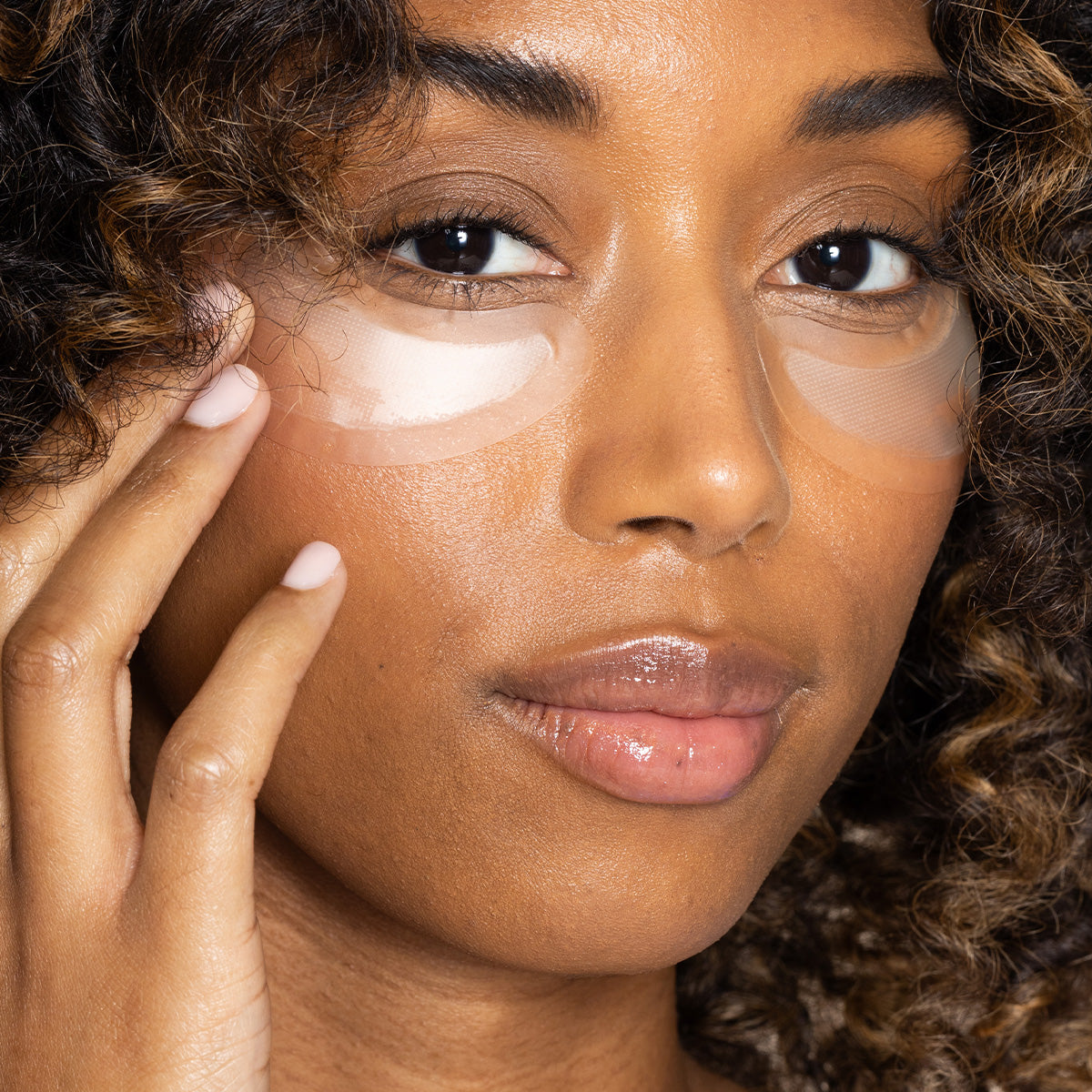 Woman wearing the Hyaluronic Acid Microneedle Eye Patches by PCA Skin