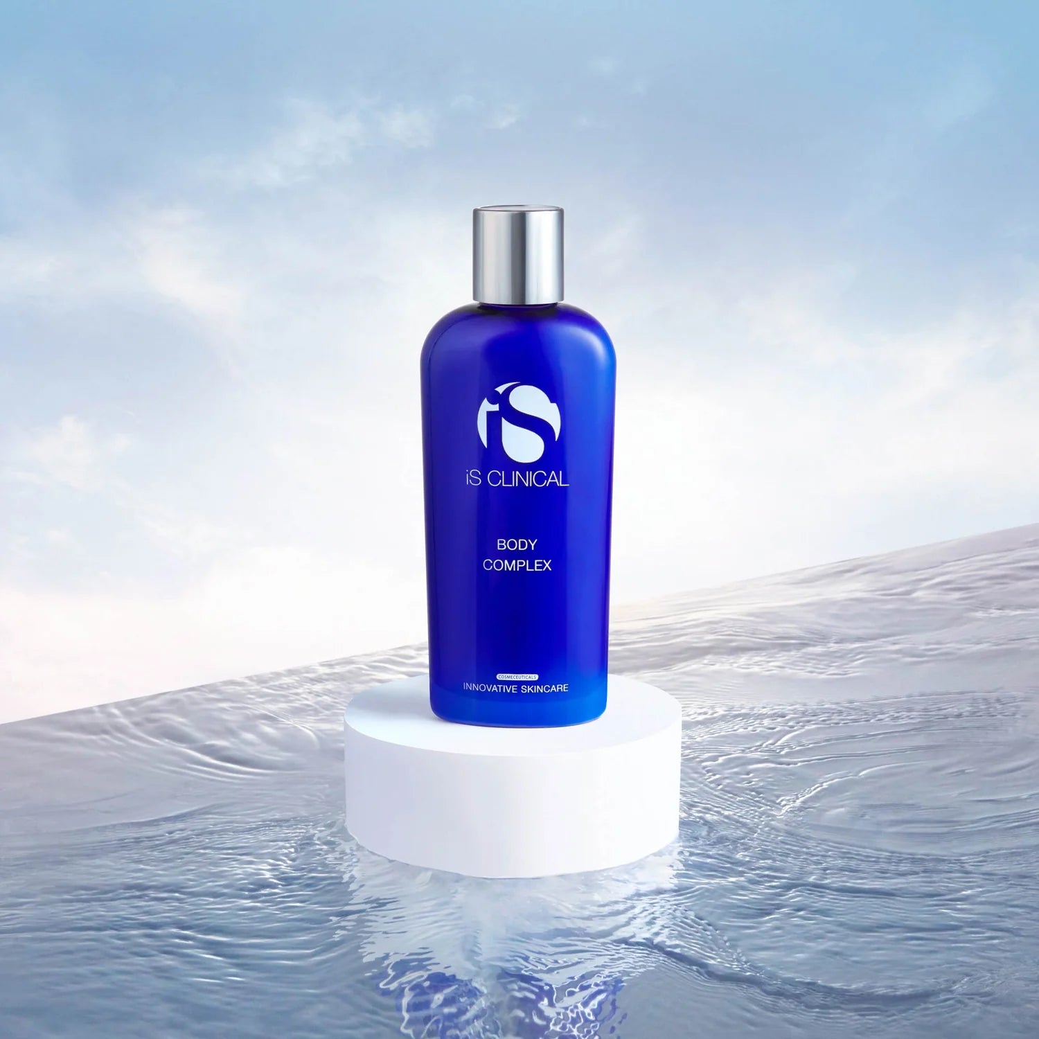 Blue bottle labeled 'iS Clinical' on a white pedestal with a water background