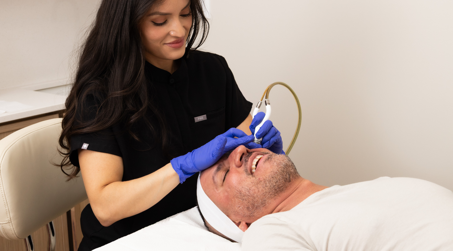 Man laying down receiving a medical facial treatment