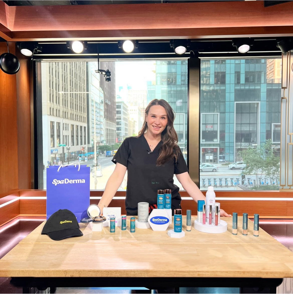 Woman standing behind a table with SpaDerma products in a studio setting.