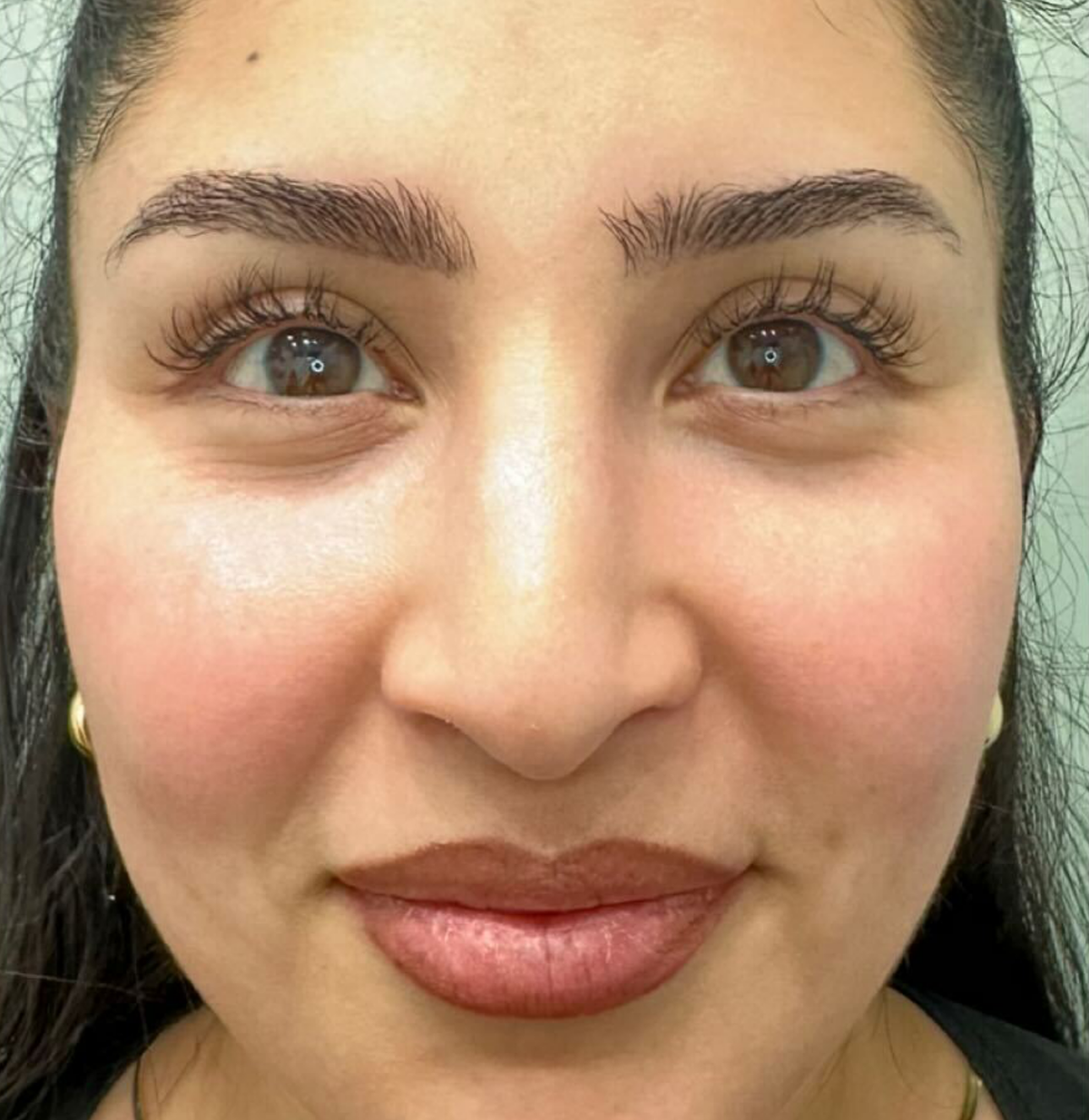 Close-up of a person with well-groomed eyebrows and clear skin.