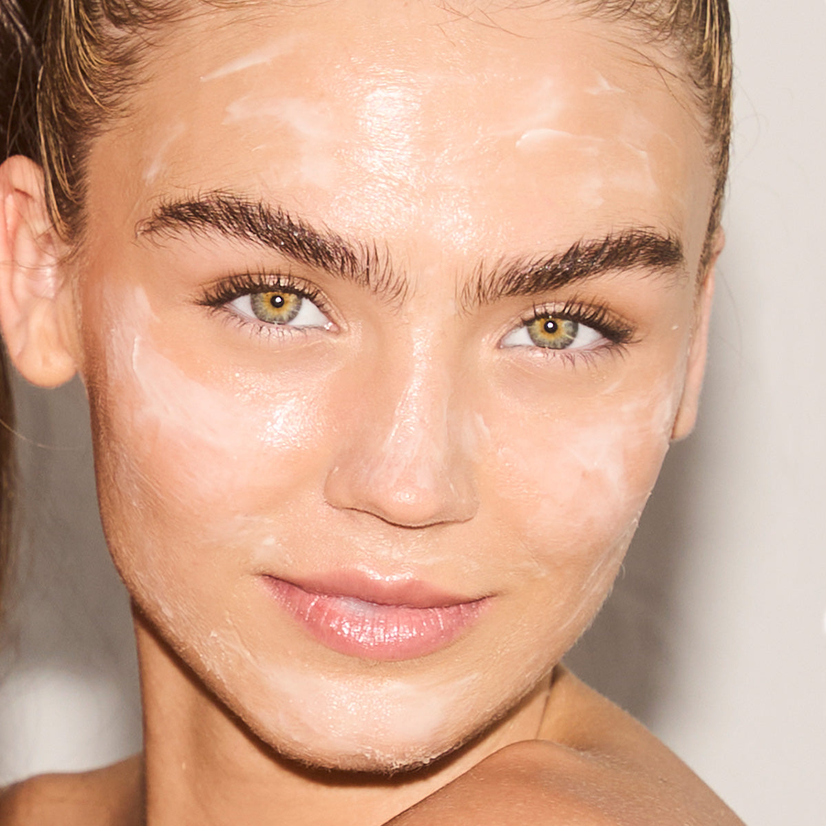 Model with cleanser all over her face