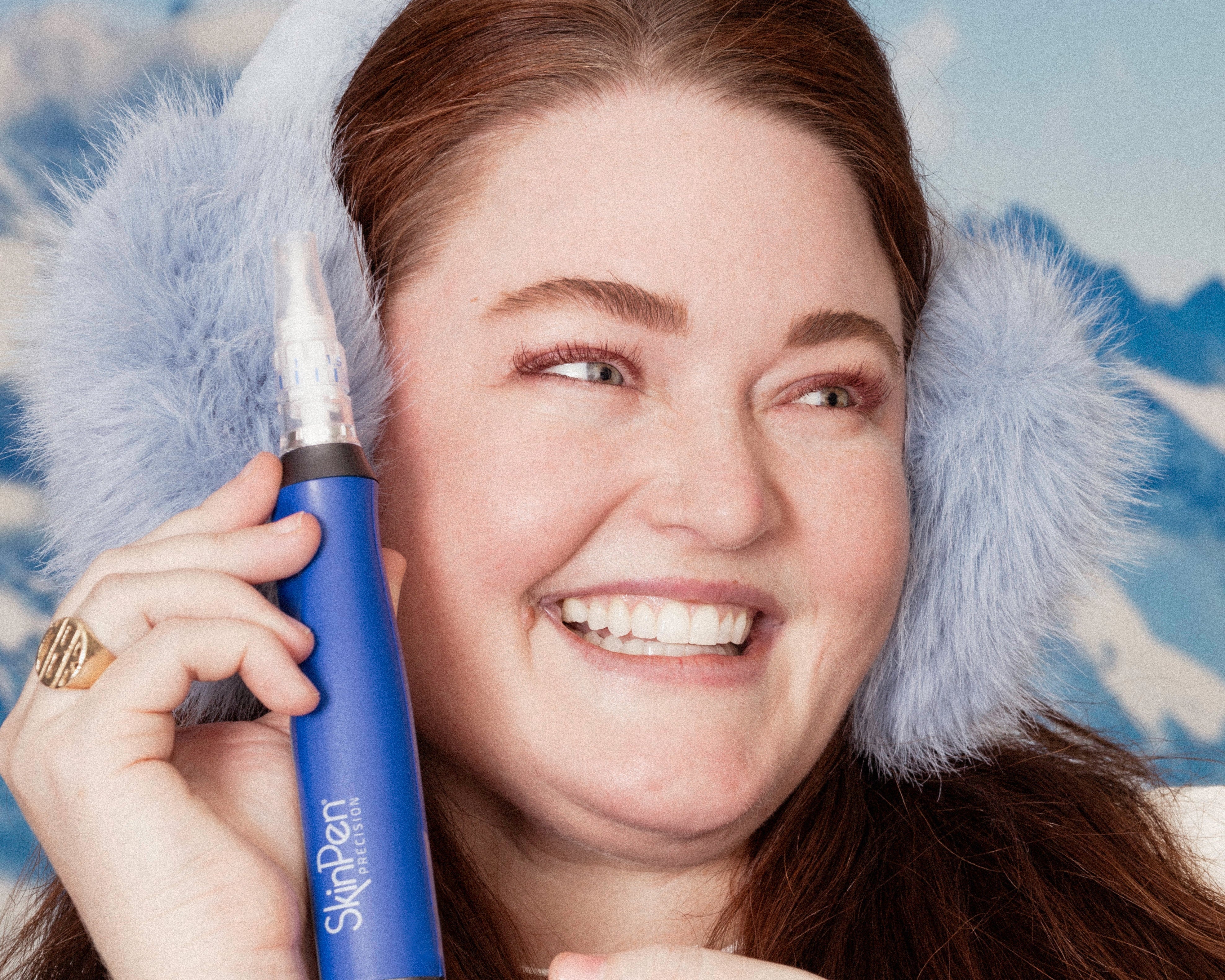 Woman wearing fur earmuffs holding a blue SkinPen with a blue background