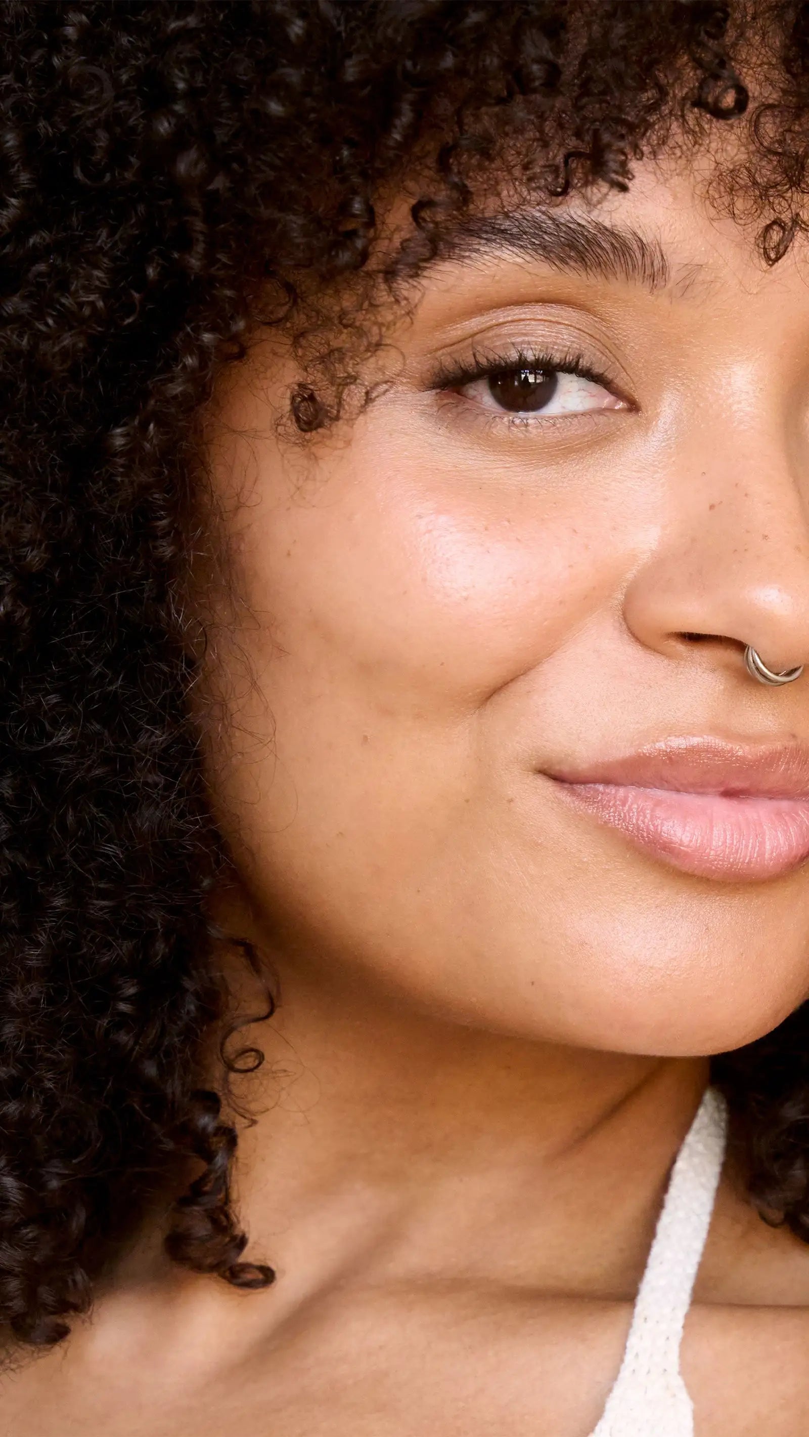 Close-up of a woman with curly hair and a white top