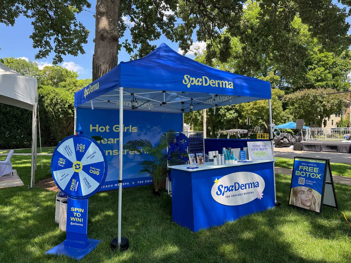 SpaDerma booth with promotional materials in a park setting