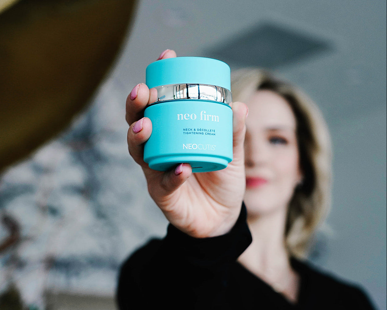 Woman holding Neo firm neck tightening cream